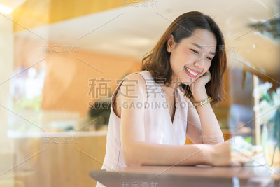 近距离观察年轻的亚洲女人微笑和阅读在家里的客厅在周末早上的生活方式和学习概念