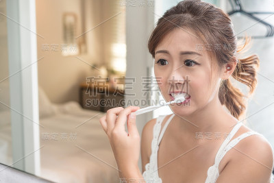 美丽的年轻女孩在她的浴室米尔刷牙