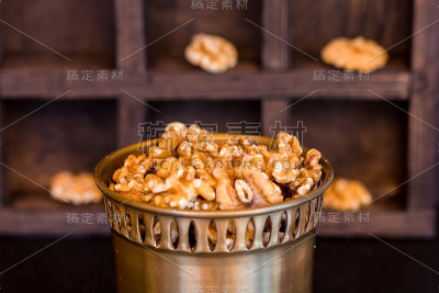 一个木盒背景上的一个铜制罐子里的核桃