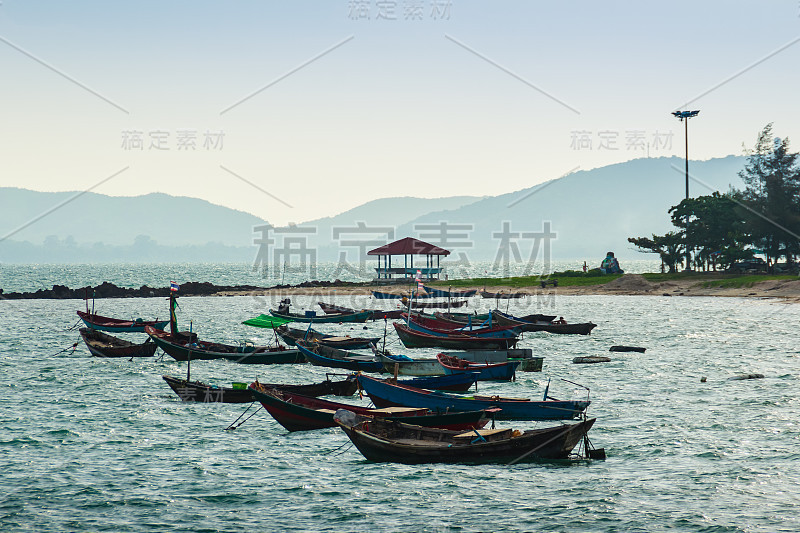 美丽的大海，沙滩和渔船与山和蓝天的背景，在泰国罗永府的帕拉海滩