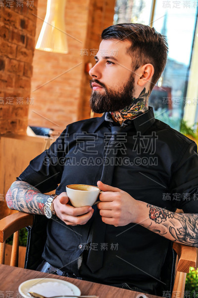 坐在咖啡馆里的纹身男子