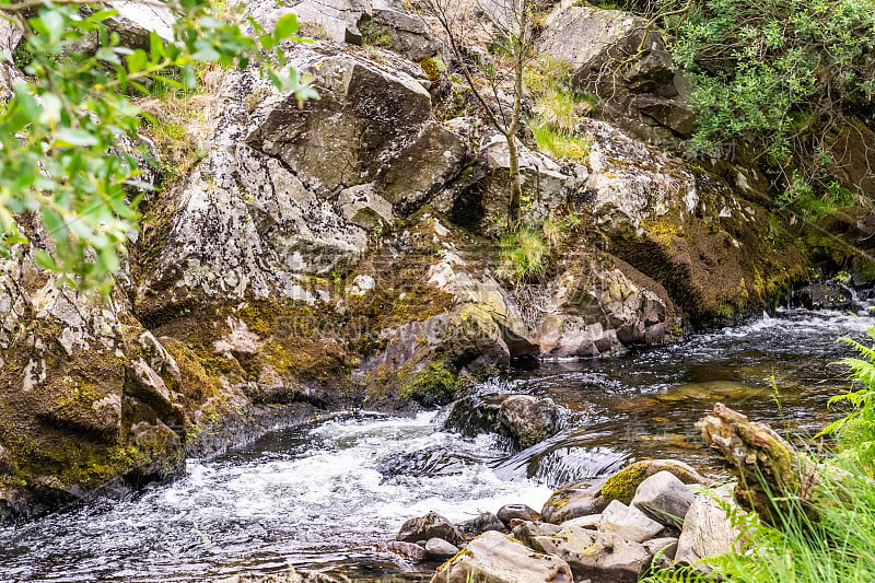 在威尔士乡村的兰贝里斯，湍急的河水从岩石上流向瀑布和瀑布池