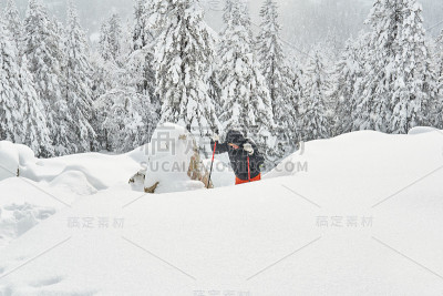 妇女在冬季的高山中徒步旅行