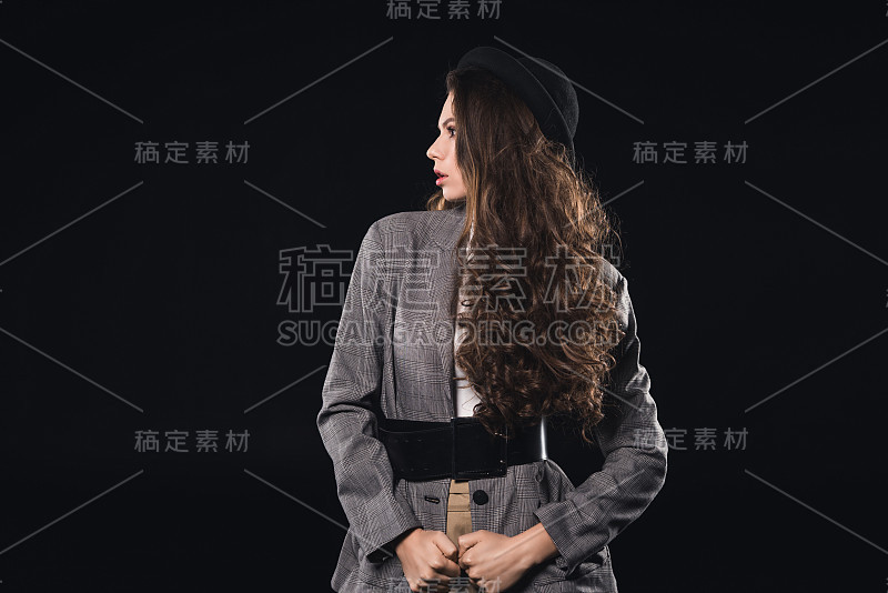 穿着黑色皮带和帽子的女人看向别处