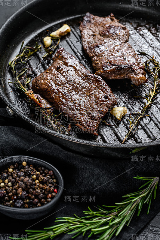 煎锅中的臀部牛排。烤的肉。黑色背景。俯视图