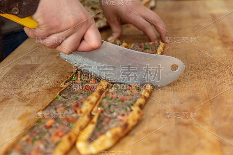 皮塔饼师傅准备好皮塔饼并把它扔进烤箱。