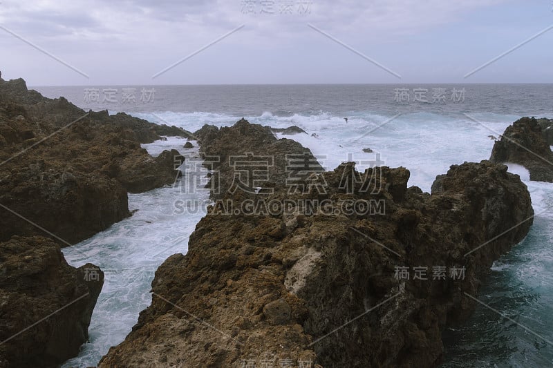 在黑暗多云的天气中，海浪在海岸线上翻滚