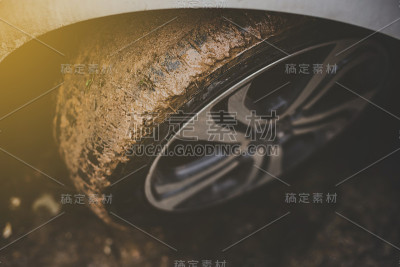 近距离看，汽车轮胎在泥地上很脏。