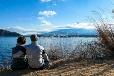 日本——一对夫妇坐在地上，从川口千子湖看富士山