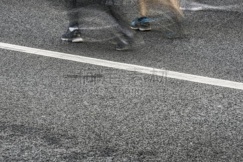 在城市街道上跑马拉松的人们。动态模糊。