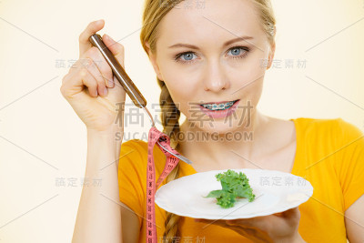 正在节食的女人拿着一盘生菜