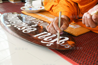 和尚在木板上做祝福标记