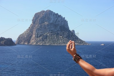 白种女孩放松做佛教冥想在悬崖前的Es Vedra岛在西班牙的海边在夏天Cala dhort