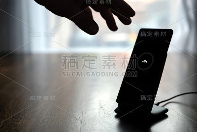 智能手机无线充电架在木桌上充电