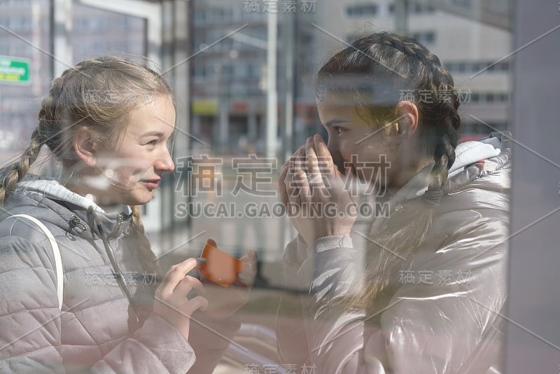 女朋友在户外用橙色的杯子喝茶或喝咖啡