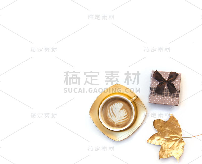 金色咖啡杯与礼盒隔离在白色。平铺，俯视图，拷贝空间