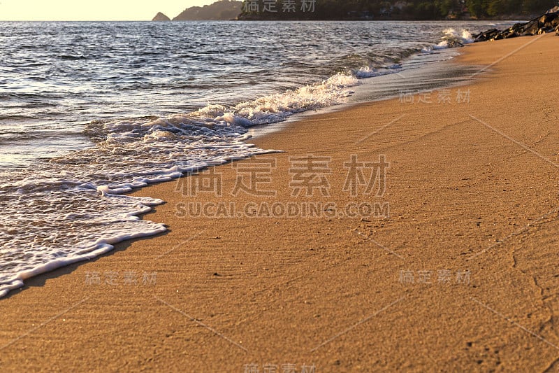 俯视图柔和的海浪从大海来到潮湿的沙滩背景。带有文本或设计的复制空间