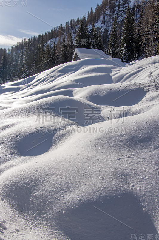 成堆的雪和山上的小屋