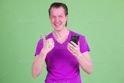 一个快乐的年轻人用手机并竖起大拇指