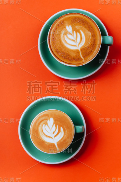橙色背景上的青色咖啡杯。