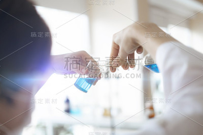 医院实验室的医护人员医生手持装有药物试剂的玻璃烧瓶