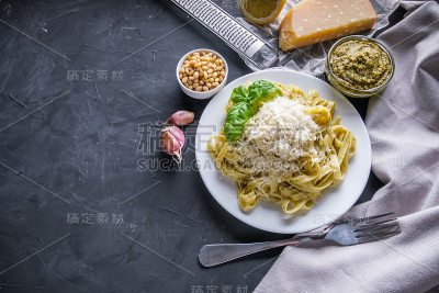 美味的意大利宽面条与香蒜酱在深色的石头背景