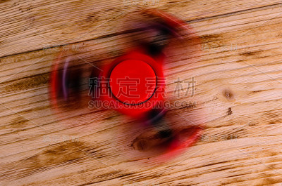 红色指尖陀螺在木桌上旋转