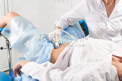 妇产科医生在做腹部下部超声波扫描的妇女的裁剪视图