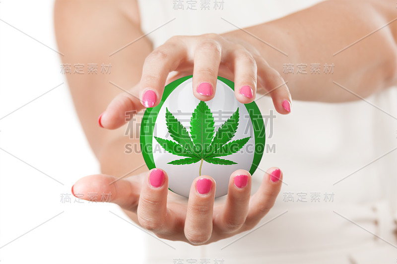 两个女人的手保护球与医用大麻或大麻大麻叶子图标