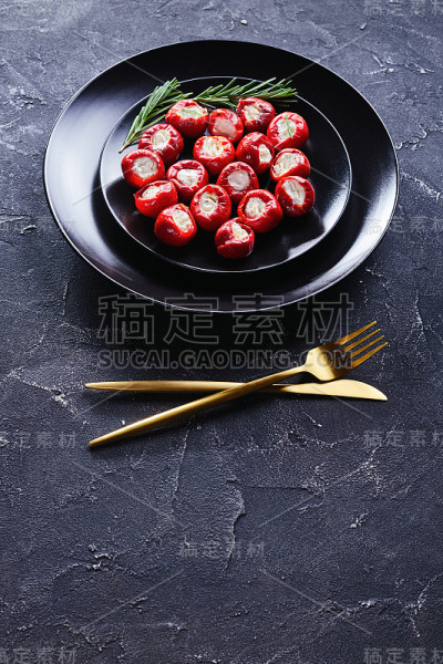 派对食物意大利乳清干酪塞热樱桃椒在一个黑色的盘子