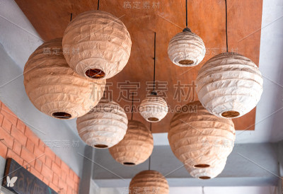 白色的圆形中国纸灯笼挂在树上，用于婚礼或宴会功能的装饰