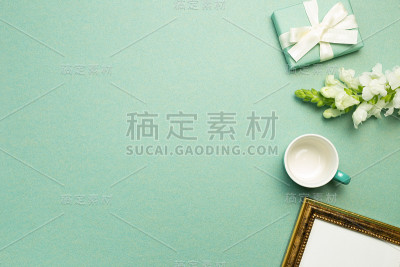 礼盒，白花，杯，相框，绿色背景。平铺，俯视图，拷贝空间