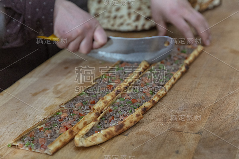 皮塔饼师傅准备好皮塔饼并把它扔进烤箱。