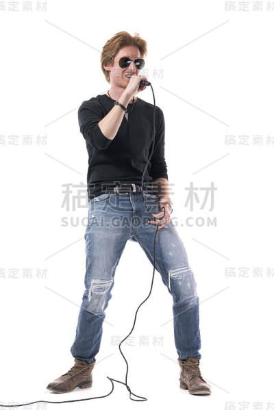 英俊的年轻歌手戴着太阳镜微笑着拿着麦克风