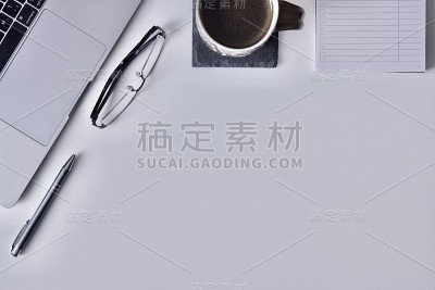 有笔记本电脑、玻璃杯、钢笔、笔芯和一杯黑咖啡的办公桌