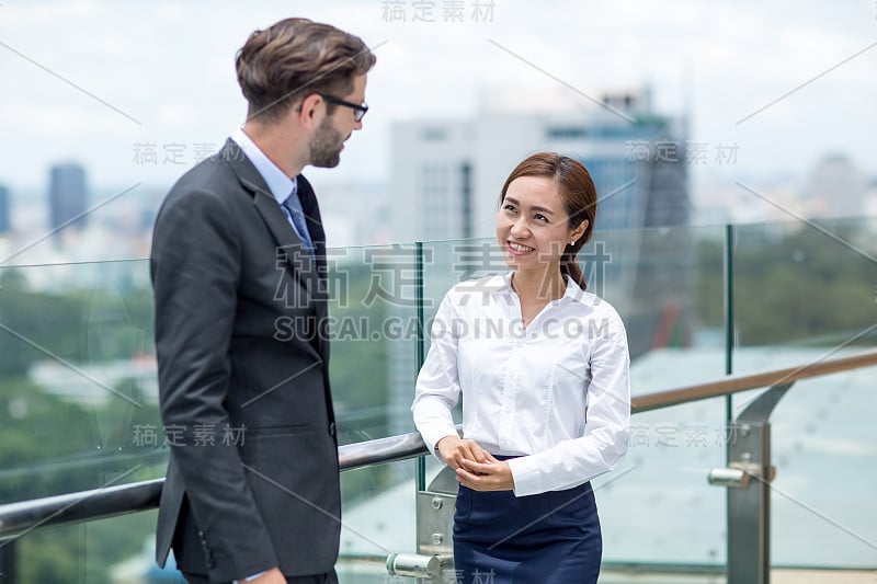 微笑的女人在屋顶上和同事聊天