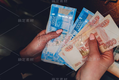 女性手中握着俄罗斯一千卢布的钞票。