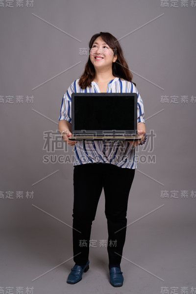 工作室拍摄的成熟美丽的亚洲女商人在灰色的背景