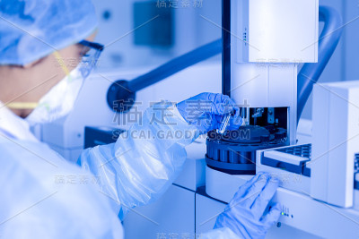 在实验室里看科学样本的女科学家。