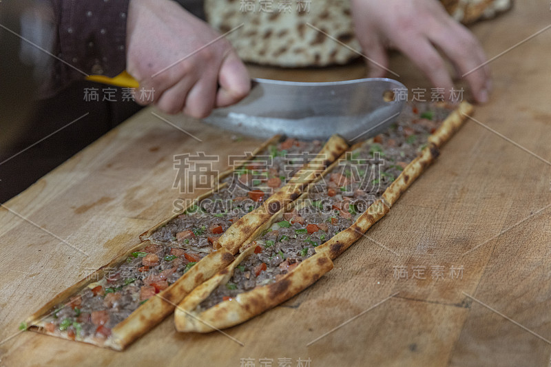 皮塔饼师傅准备好皮塔饼并把它扔进烤箱。