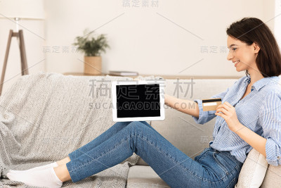 年轻女子坐在沙发上购物