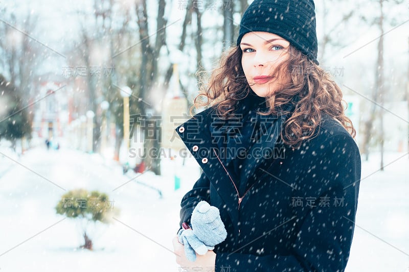 下雪的时候，穿着外套的年轻迷人的女人走在街上