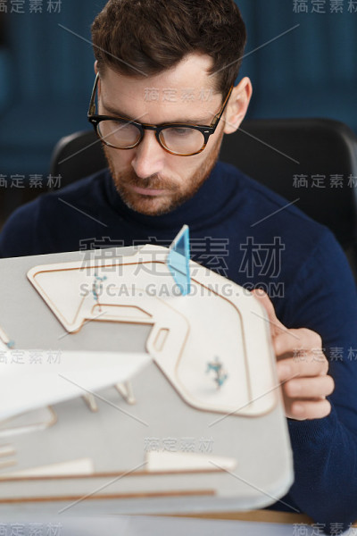建筑师在办公室工作，建立3D模型。工程师检查建筑布局，为建筑项目寻找新的思路。在工作场所英俊的胡子男