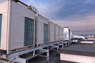 新工业建筑屋顶上的空调机组VRV (HVAC)、大风扇和水冷却器，背景是蓝天和白云。