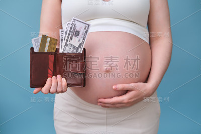 带着钱包，钱和信用卡的孕妇，蓝色背景