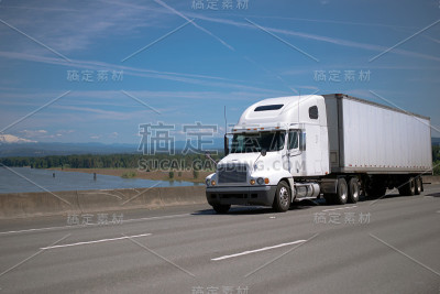 现代引擎盖白色大卡车半挂车半挂车驾驶在壮观的高速公路