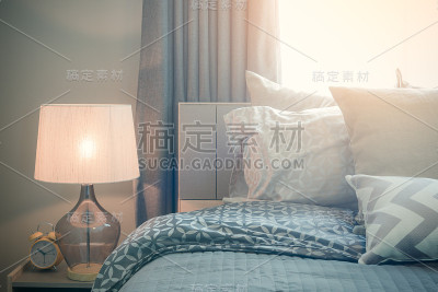 经典的台灯风格与闹钟在舒适的卧室的桌子边