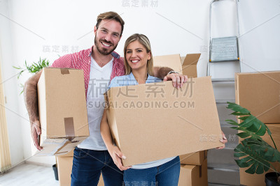 一对年轻夫妇拿着箱子准备搬家