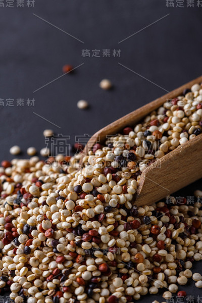 在黑色的石头背景上混合藜麦颗粒