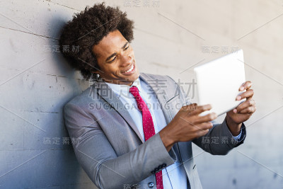 在城市背景中使用数字平板电脑的黑人商人